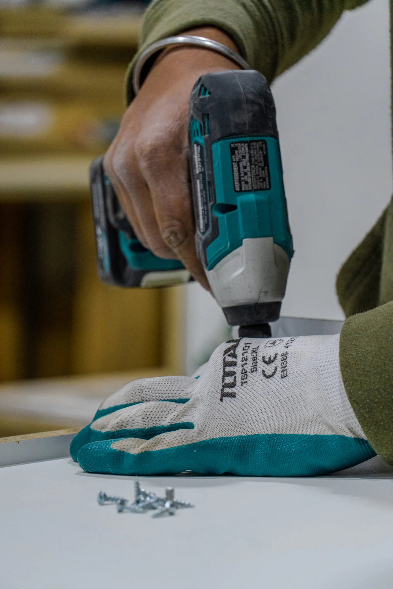 Tevola installer fastening a cabinet with a cordless drill
