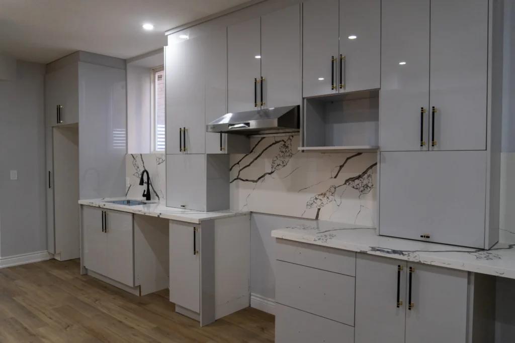 Grey high-gloss custom kitchen with handleless lower cabinets and a stainless hood