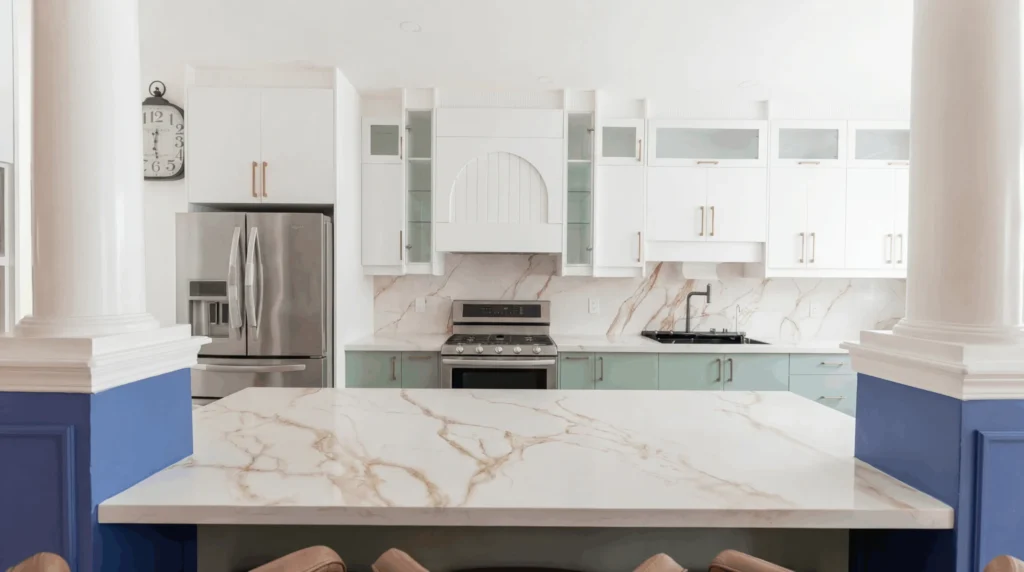 Custom kitchen with white upper cabinets, sage green lowers and a marble backsplash