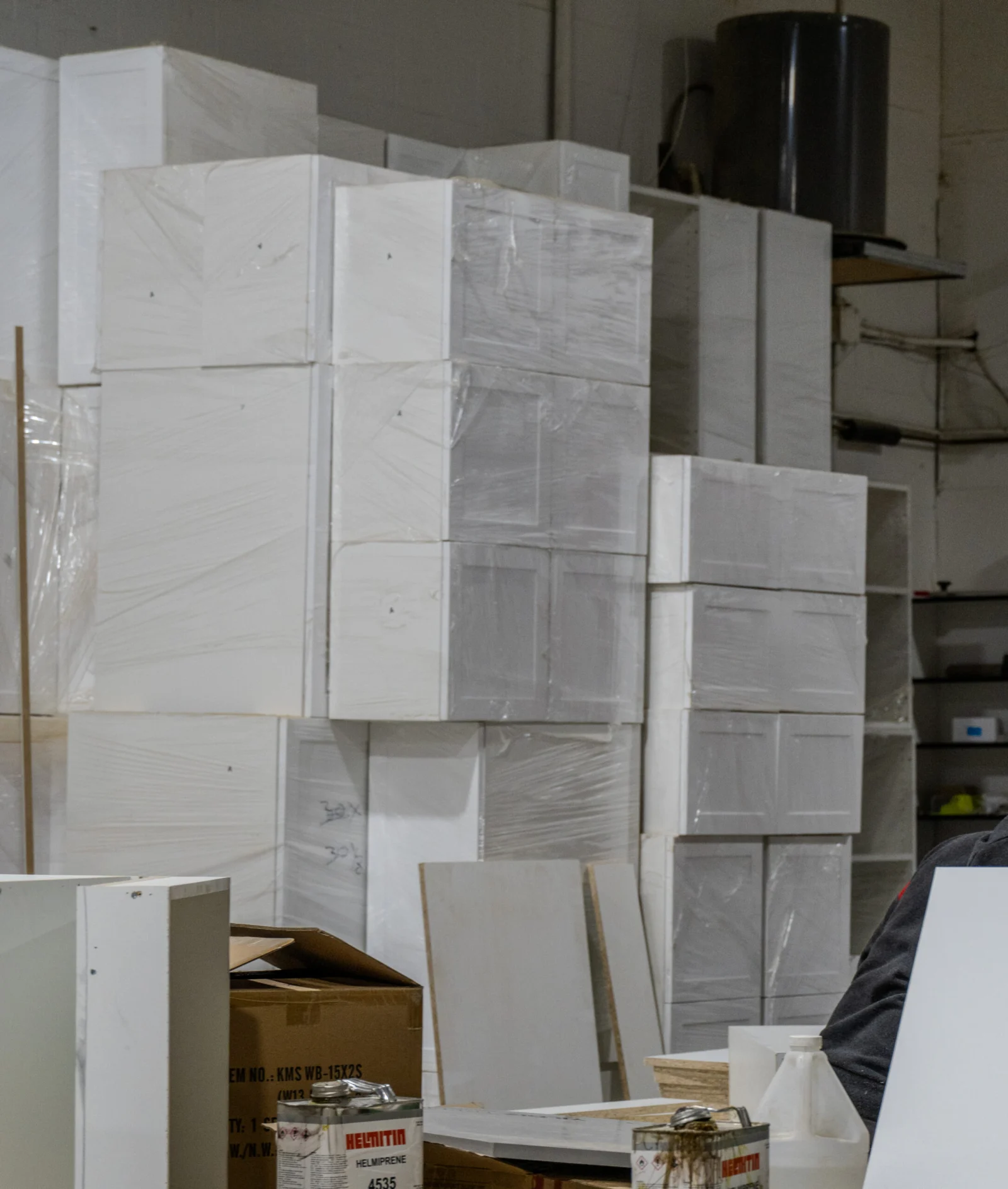 Finished white cabinet boxes stacked in the Tevola workshop before delivery
