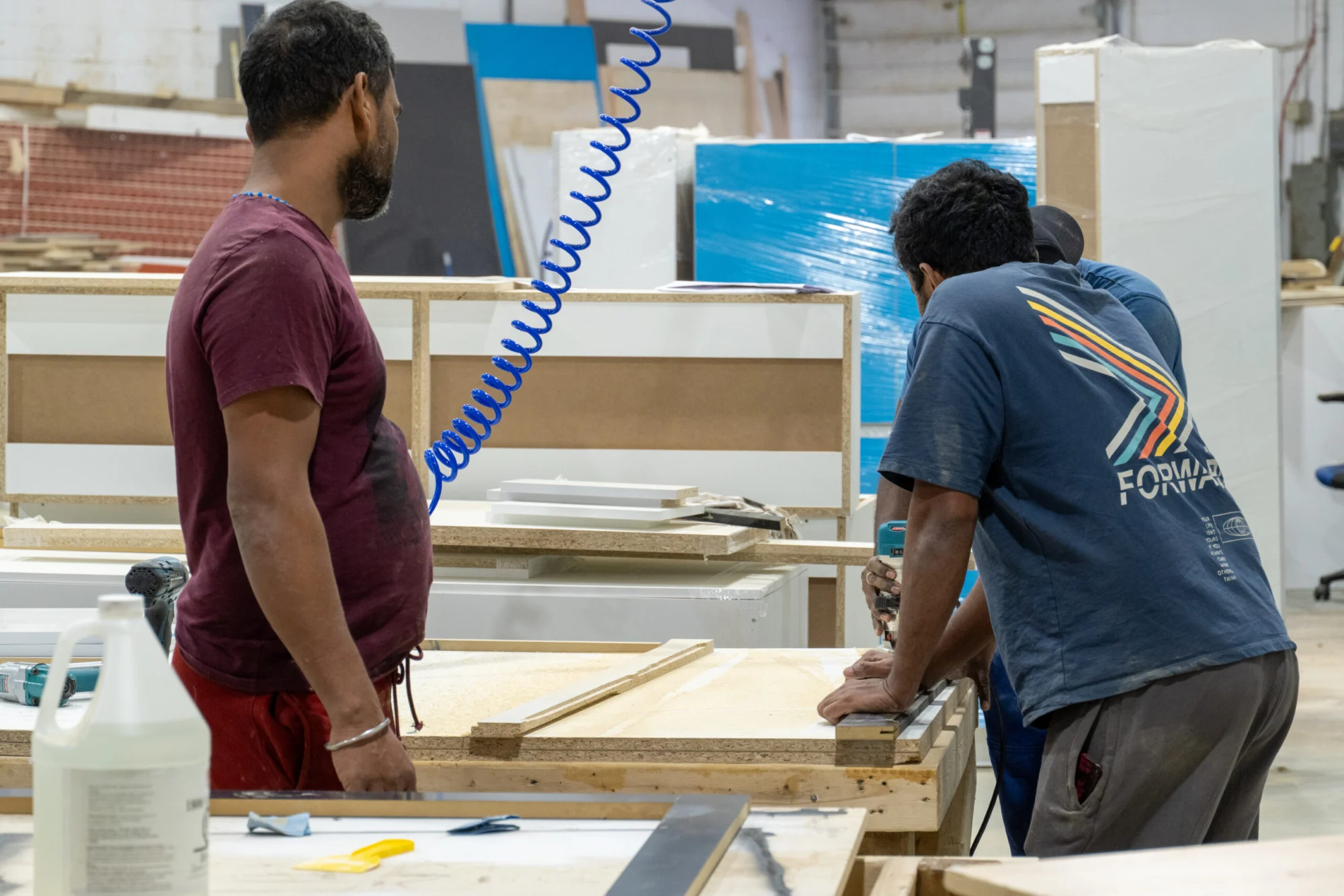 Two Tevola cabinet makers working at a bench in the Scarborough shop