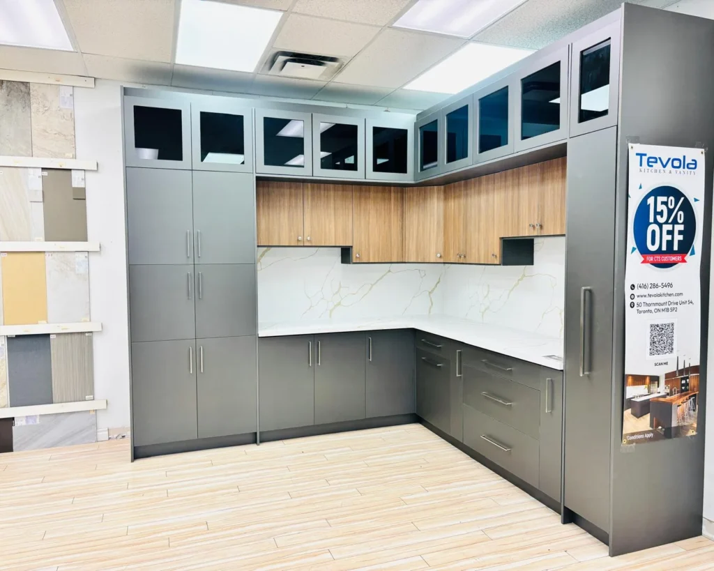 Showroom display with grey lower and tall cabinets, wood upper cabinets and a marble backsplash
